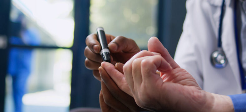 Doctor consulting senior patient with glucometer, measuring insulin and glucose level from blood sample. Medic and old man doing diabetic control during checkup visit consultation in hospital lobby.